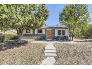 Charming single-story home featuring a gray exterior with an orange front door and mature trees at 5330 S Windermere St, Littleton, CO 80120