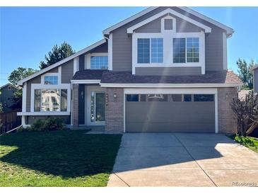 Inviting two-story home featuring a well-manicured lawn, attached garage, and beautiful curb appeal at 9668 Salem Ct, Highlands Ranch, CO 80130