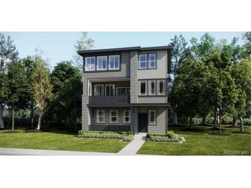 Contemporary three-story home with gray siding, black trim, balcony, and manicured lawn at 7308 Waterleaf Trl, Littleton, CO 80125