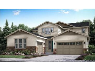 Charming two-story home with a large two car garage and stone accents near the front door at 14553 Hudson Way, Thornton, CO 80602