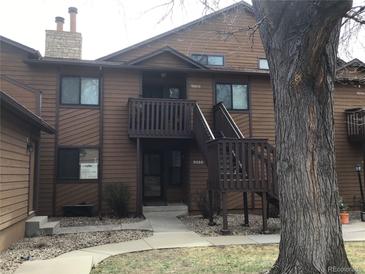 Exterior of a two-story brown wood condo with stairwell and visible house numbers at 9088 W 88Th Cir, Westminster, CO 80021