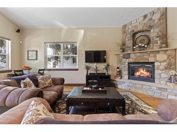 Cozy living room with a stone fireplace, plush sofas, with an open layout perfect for relaxation at 493 Cr 672, Breckenridge, CO 80424