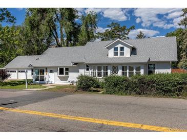 Charming single-story home featuring white siding, gray shingle roof, and lush landscaping at 5195 Allison St, Arvada, CO 80002