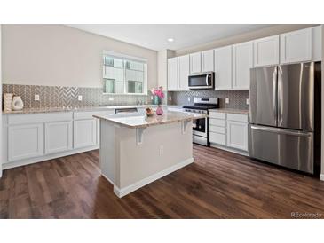 Modern kitchen with white cabinetry, stainless steel appliances, granite countertops, and center island at 1330 Independence St # 2, Lakewood, CO 80215