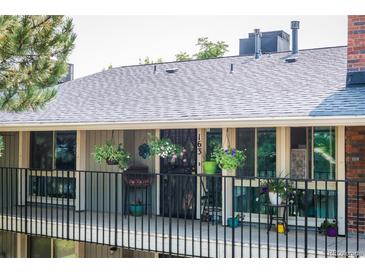 A charming balcony with black iron railings is adorned with an array of colorful flowers and plants at 6495 E Happy Canyon Rd # 163, Denver, CO 80237
