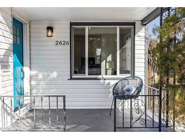 Cozy front porch with a blue door, modern wall lighting, and wrought iron railings offer street views at 2626 S Pennsylvania St, Denver, CO 80210