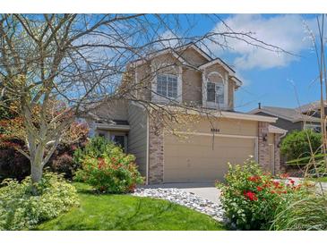 Charming two-story home featuring a well-manicured lawn, beautiful landscaping, and a two-car garage at 8884 Miners St, Highlands Ranch, CO 80126