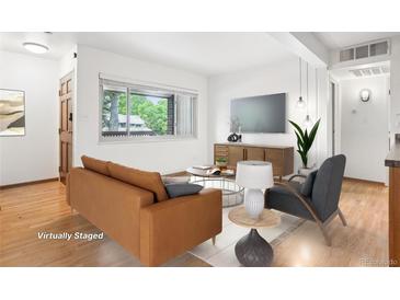Bright living room featuring a modern design, wood floors, and large windows for natural light at 3663 S Sheridan Blvd # H15, Denver, CO 80235