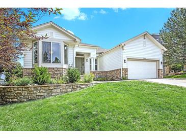 Charming home featuring a well-manicured lawn, stone accents, and a bright exterior at 7410 Winter Berry Ln, Castle Pines, CO 80108