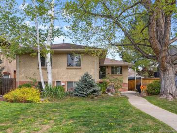 Charming brick home featuring mature trees, manicured lawn, and lush landscaping at 746 Birch St, Denver, CO 80220