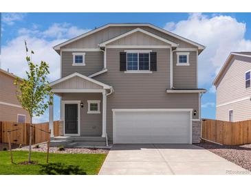 Charming two-story home featuring a two car garage, gray siding and a well-maintained front yard with lawn at 48195 Shetland Dr, Bennett, CO 80102