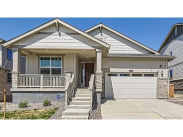 Charming home featuring a covered porch, stone accents, and a two-car garage at 1159 Sunrise Dr, Erie, CO 80516