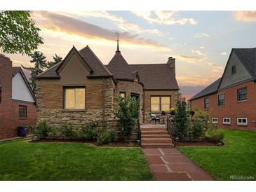 Charming stone home with a manicured lawn and inviting front porch at 3050 Bellaire St, Denver, CO 80207