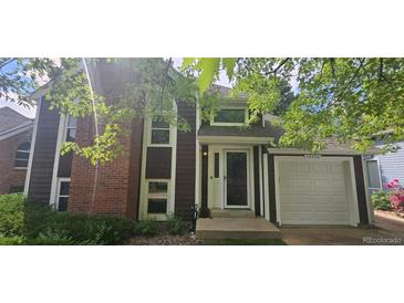 Charming home with a brick and wood facade, complemented by a well-maintained lawn and an attached one-car garage at 16724 E Hialeah Ave, Centennial, CO 80015