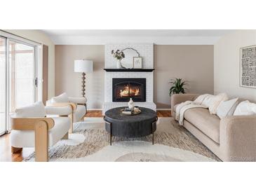 Cozy living room with a white brick fireplace and modern furnishings for comfortable lounging at 8856 W Prentice Ave, Littleton, CO 80123