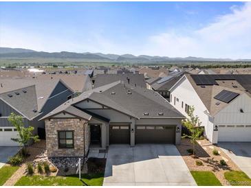 A lovely gray two-story home features a stone accent wall and a two-car garage at 11383 Autumn Moon St, Littleton, CO 80125