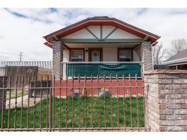 Charming home featuring a well-maintained front yard, secure fencing, and a welcoming porch at 4849 Lincoln St, Denver, CO 80216