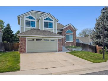 Charming two-story home featuring a brick and siding exterior with attached two car garage at 8229 S Ogden Cir, Littleton, CO 80122