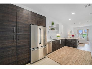 Stylish kitchen boasting stainless steel appliances, wood cabinetry, and an open-concept design at 2530 Lawrence St # Ra301, Denver, CO 80205