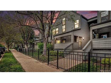 Charming townhouse with gray siding, a cozy porch, and a manicured front yard at 2 Acoma St # 11, Denver, CO 80223