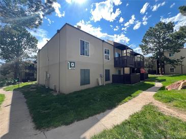 Two-story condo building with wooden balconies, landscaping and pathway at 9995 E Harvard Ave # 261, Denver, CO 80231