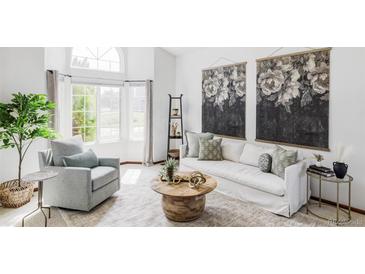 Bright living room featuring a plush sofa, accent chair, and stylish decor at 9257 Shadowglen Ct, Highlands Ranch, CO 80126