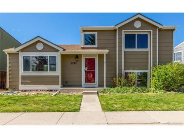 Charming home with a red door, well-kept lawn, and lovely landscaping at 5733 Whitechapel St, Castle Rock, CO 80104