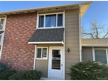 Brick front exterior of a bi-level home with a white door at 2218 Coronado N Pkwy # B, Denver, CO 80229