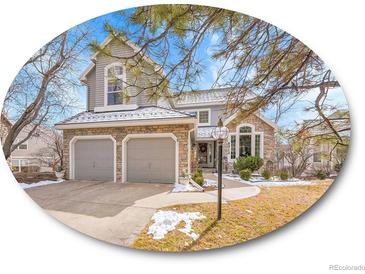 Charming two-story home with stone accents, a two-car garage, and manicured landscaping at 8312 S Peninsula Dr, Littleton, CO 80120