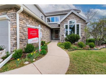 Charming stone front exterior with landscaped walkway and Steller Group real estate sign at 8312 S Peninsula Dr, Littleton, CO 80120