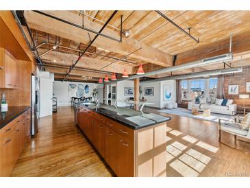 Bright, open kitchen with granite countertops and stainless steel appliances flows into a spacious living area at 1616 14Th St # 4E, Denver, CO 80202