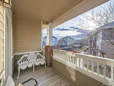 Inviting covered porch with white railing and ornate white metal bench seating at 8481 W Union Ave # 4-203, Littleton, CO 80123