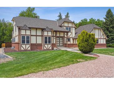 Stunning exterior showcasing Tudor style, large yard, and brick accents at 4855 S Joplin St, Aurora, CO 80015