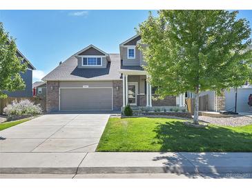 Charming two-story home with a manicured lawn, tree and inviting front porch, and a two car garage at 4037 S Odessa Cir, Aurora, CO 80013