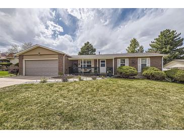 Charming brick home with a well-manicured lawn, attached garage, and inviting front porch at 6267 S Albion Ct, Centennial, CO 80121