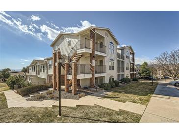 Multi-level condo building with brick accents, walkways and green space on a sunny day at 1648 S Cole St # A2, Lakewood, CO 80228