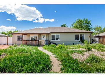 Charming single-story home featuring a cozy porch and a spacious front yard with lush greenery at 1151 Revere St, Aurora, CO 80011