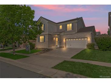 Charming two-story home with brick accents, a well-manicured lawn, and a two-car garage under a beautiful sunset at 1160 S Fultondale Ct, Aurora, CO 80018