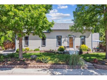 Charming single-story home with a well-maintained lawn, flower beds, and lovely curb appeal at 2311 W 46Th Ave, Denver, CO 80211