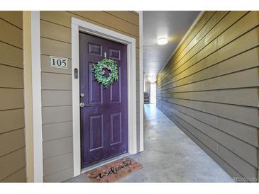 Condo front door with a wreath and welcome mat, leading to the unit's entrance and the hallway at 17442 Nature Walk Trl # 105, Parker, CO 80134