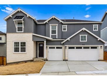 Charming two-story home featuring a 2-car garage and stone and vinyl siding at 9322 Quaker St, Arvada, CO 80007