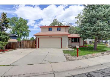 Charming two-story home with a brick facade, a two-car garage, and a well-maintained front yard at 7552 Garland St, Arvada, CO 80005
