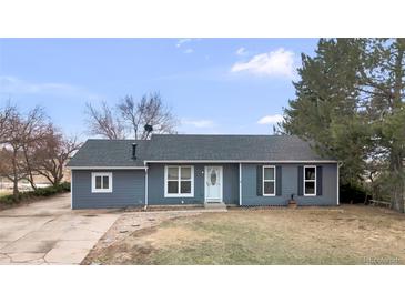 Charming single-story home with blue siding, a well-maintained lawn, and mature trees at 6680 E Rustic Dr, Parker, CO 80138