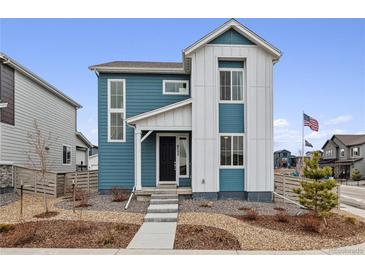 Charming two-story home features blue and white siding, landscaped front yard, and inviting entryway at 8733 Arriba Dr, Littleton, CO 80125