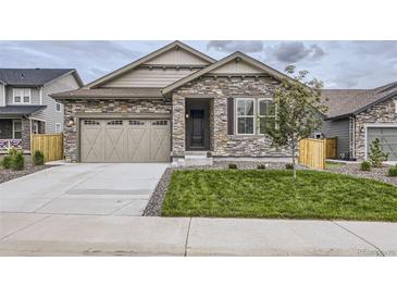 Charming single-Gathering home featuring a stone facade and a two-car garage with modern doors at 15376 Ivanhoe Ct, Thornton, CO 80602