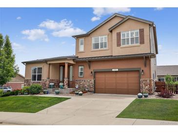 Beautiful two-story home with a stone facade and a well-maintained lawn at 436 Sage Grouse Cir, Castle Rock, CO 80109