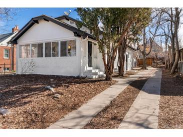 Charming exterior view of home with a front yard featuring wood mulch and concrete driveway leading to the front entrance at 1858 S Lincoln St, Denver, CO 80210