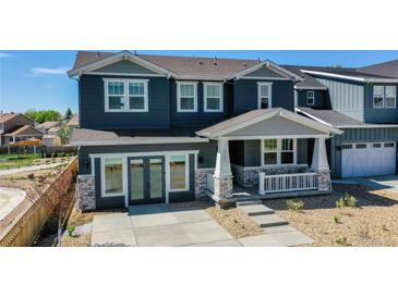 Two-story home with gray siding, stone accents, and a front porch at 2980 E 102Nd Pl, Thornton, CO 80229
