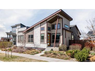 Striking exterior of a modern home featuring unique architectural details and manicured landscaping at 9091 E 61St Ave, Denver, CO 80238
