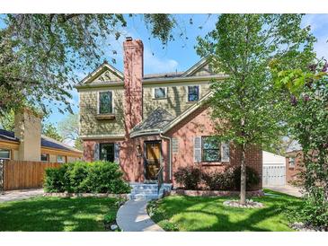 Charming two-story home featuring brick and siding, complemented by lush landscaping and a welcoming walkway at 1109 Jersey St, Denver, CO 80220